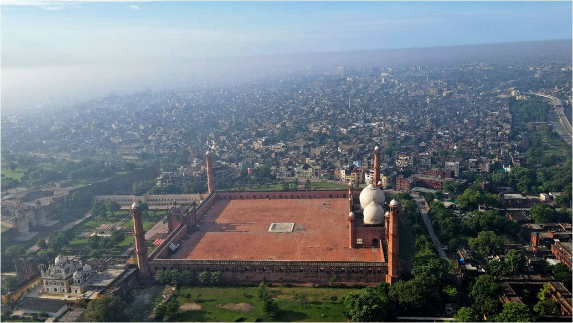 A vibrant aerial view of Lahore with the iconic Badshahi Mosque in the background