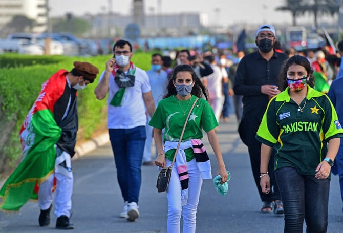 fans entering the stadium, wearing cricket merchandise